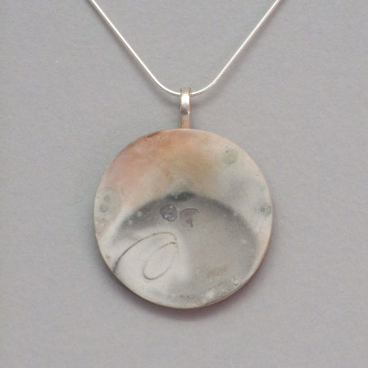 Pink and grey smoke fired ceramic pendant with a grey swirl on a silver necklace